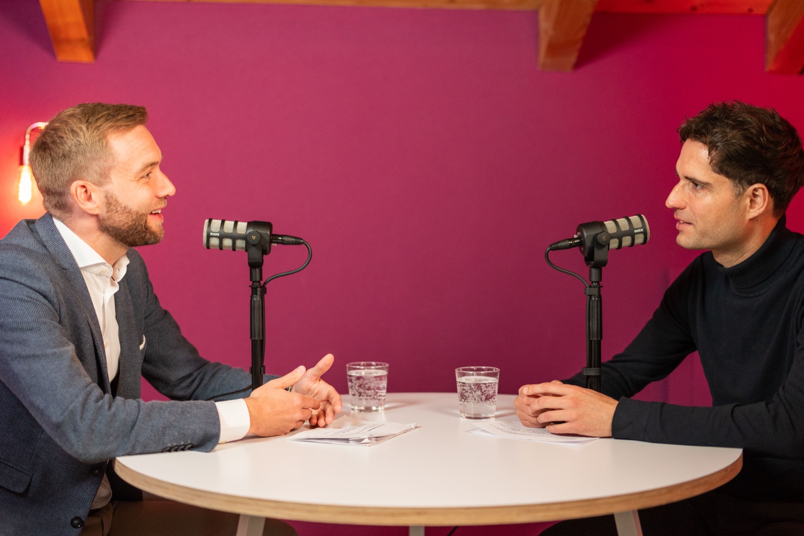 Zwei Personen im Podcast-Gespräch am Studiotisch