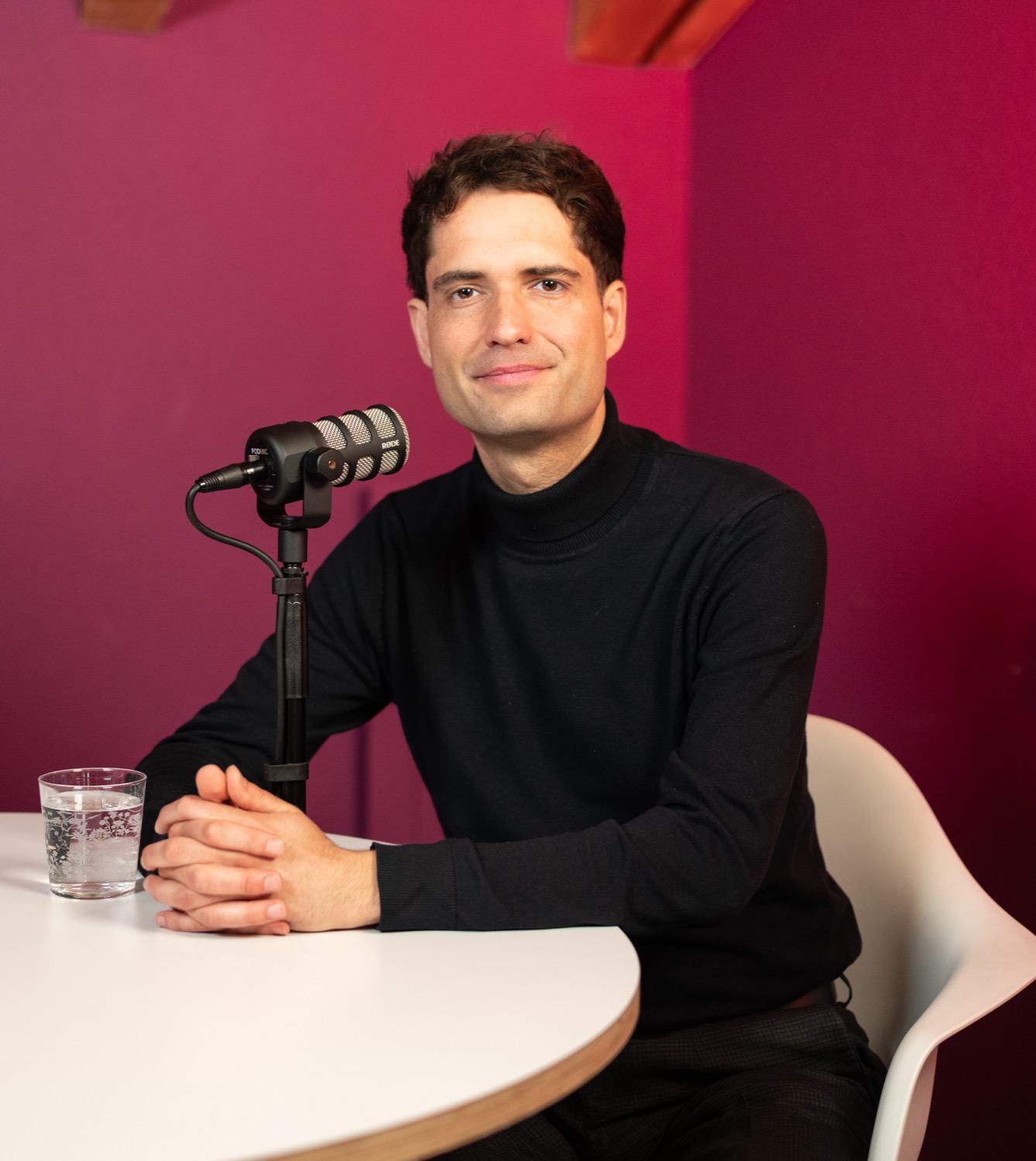 Gast am Mikrofon, Porträt vor magentafarbener Wand